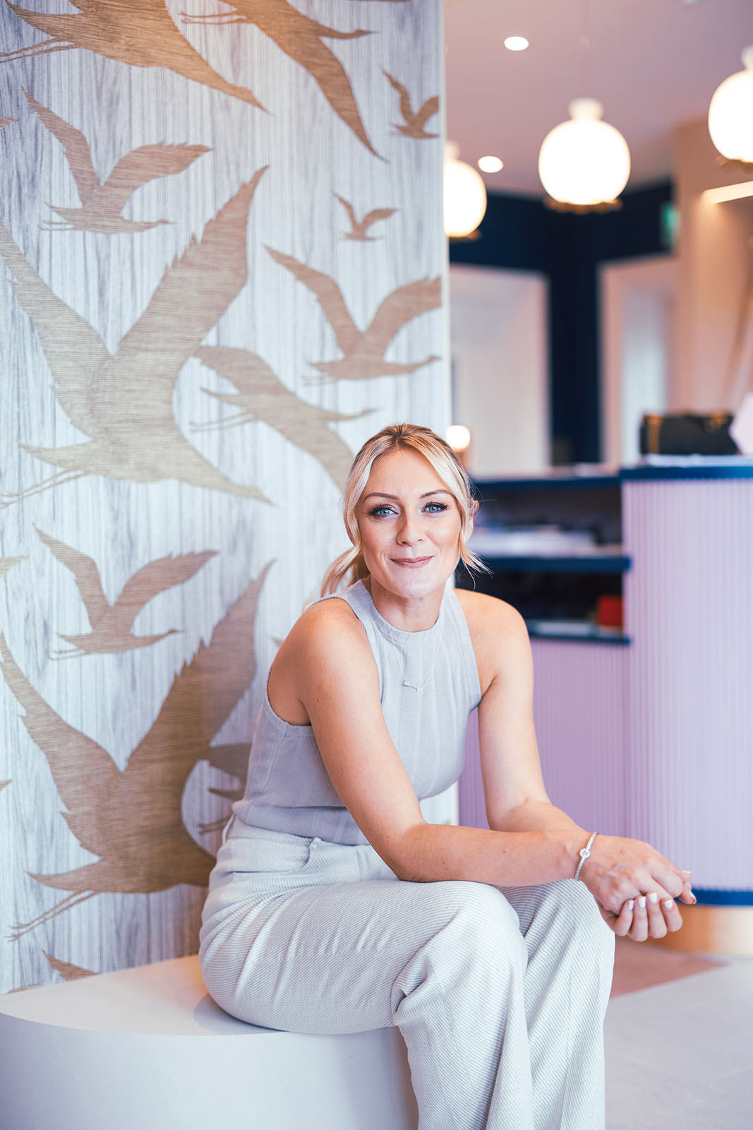 Photo of Little Bird Boutique's owner sat down looking towards camera.